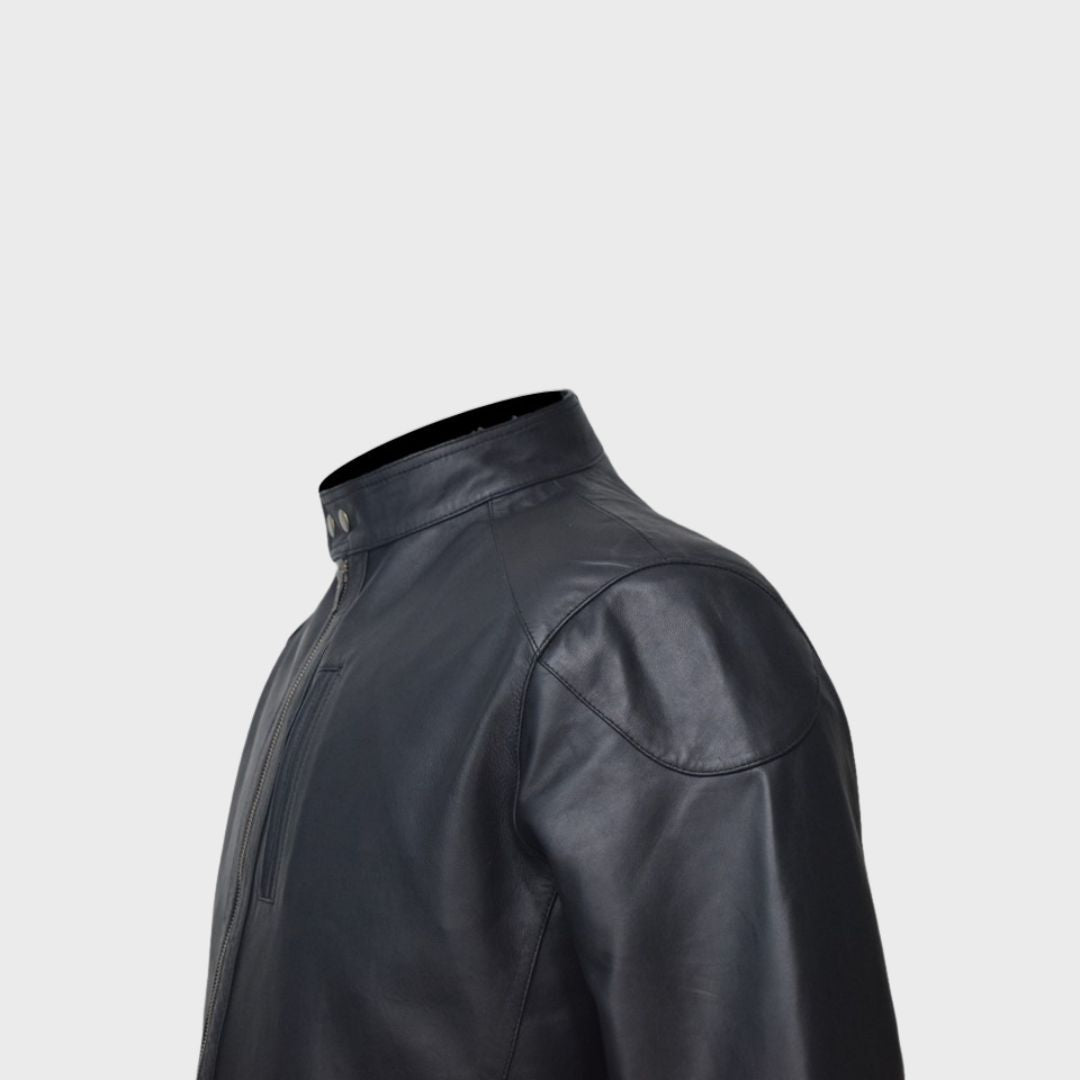 Detailed shot of the zipper fastening chest pocket on a black leather biker jacket.