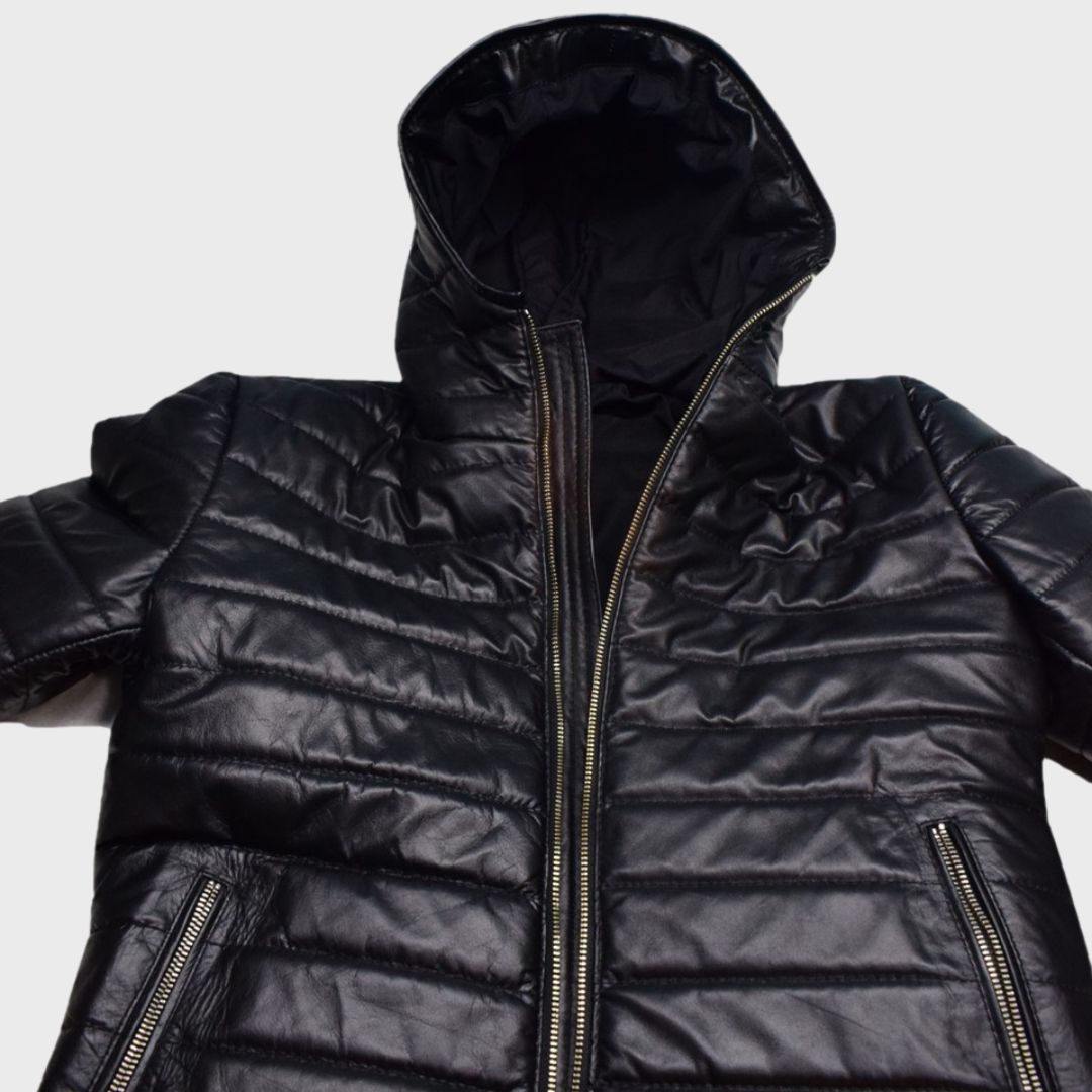 Close-up of black leather puffer jacket with zipper fastening, zipper pockets and hood.