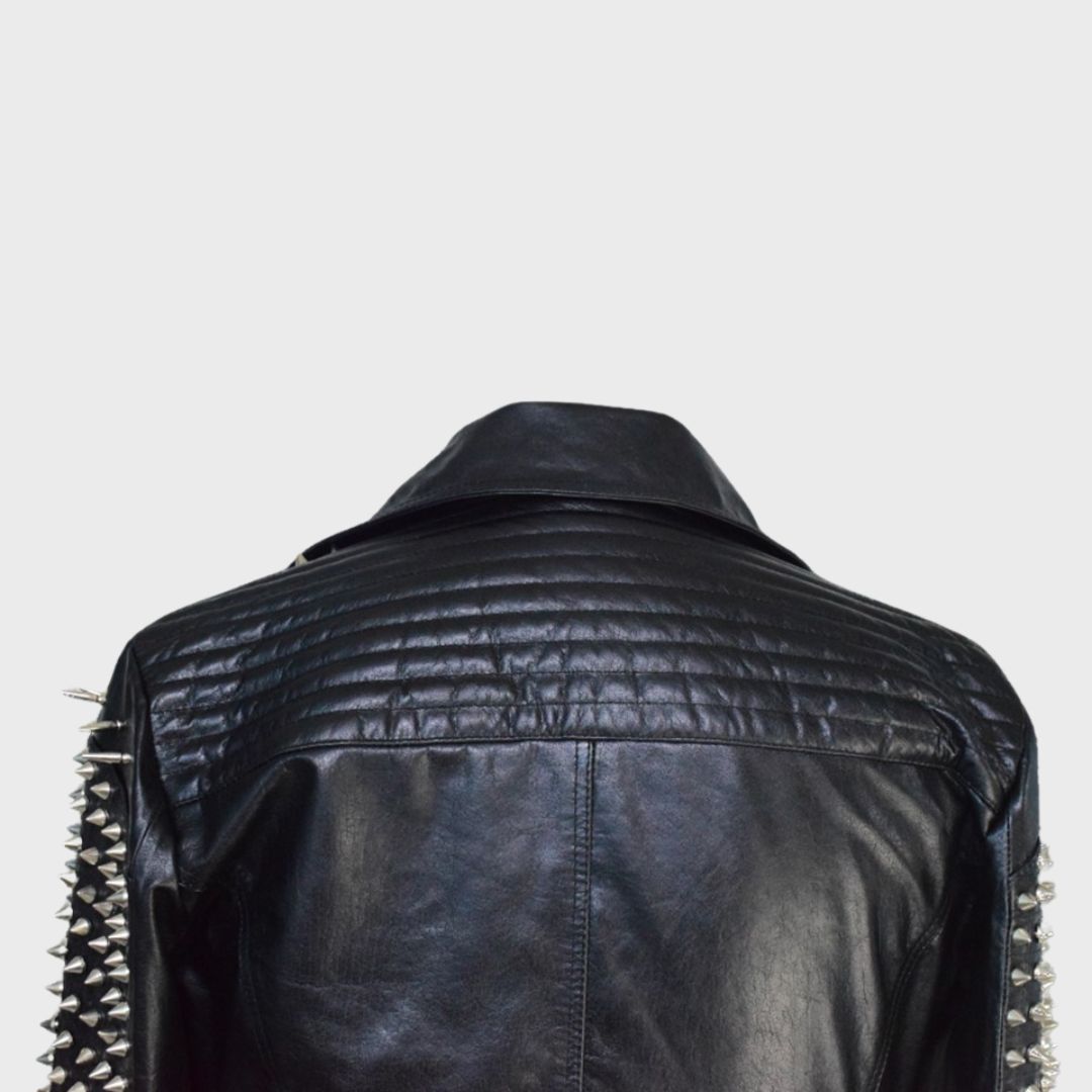 Closeup of shoulder of black leather studded biker jacket handmade with lambskin. Features Silver studs, zipper fastening, notch collar, zipper pockets.