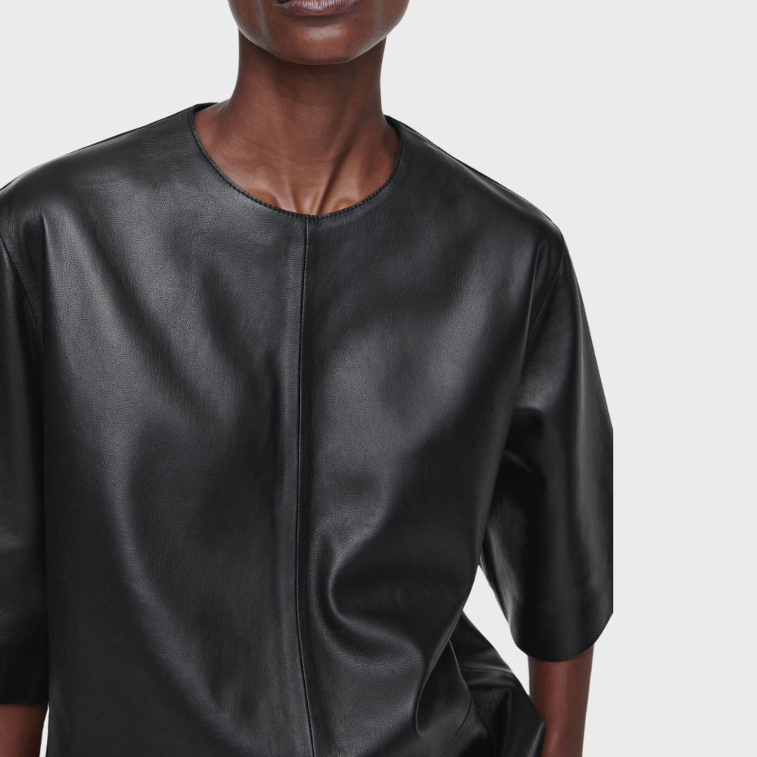 Black woman wearing black leather shirt with zipper fastening closure